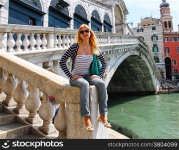 Attractive girl in a sunny day on a bridge in Venice, Italy