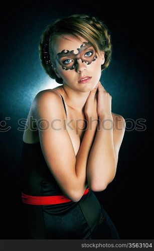 Attractive girl in facial carnival mask looking at camera - studio shot. Series of photos