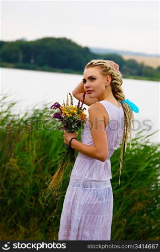 attractive girl in wet dress with flowers in hands. outdoor shot
