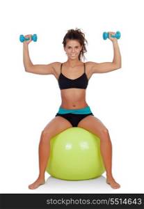 Attractive girl lifting dumbbells sitting on a ball isolated on a white background