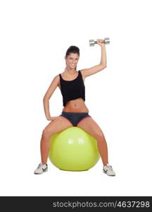 Attractive girl lifting weights sitting on a ball isolated on white background