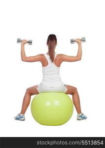 Attractive girl lifting weights sitting on a ball isolated on white background