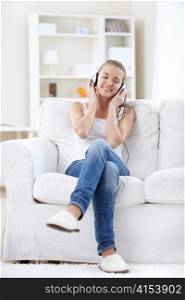 Attractive girl listening music with headphones at home