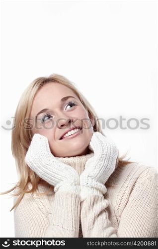 Attractive girl looks up in mittens on a white background