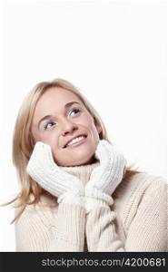 Attractive girl looks up in mittens on a white background