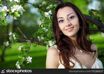 Attractive girl on a background of flowering trees