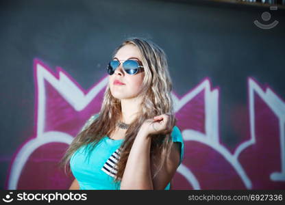 Attractive girl on a wall background with graffiti. close-up