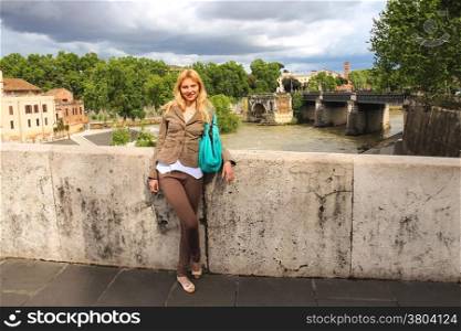 Attractive girl on the bridge across the Tiber in Rome, Italy