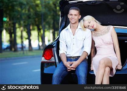 Attractive girl put her head on the shoulders of men in the car