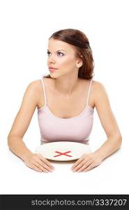 Attractive girl sits before empty plate with an interdiction sign