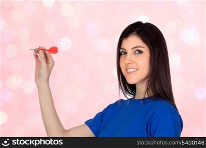 Attractive girl smiling throwing a dart isolated on a bright background