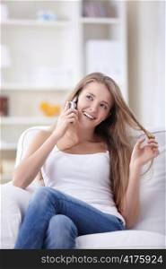 Attractive girl talking on the phone on the couch