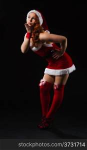 Attractive girl wearing on Santa Claus costume, full length composition and black background