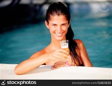 Attractive girl with a glass of champagne in the pool