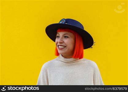 Attractive girl with a hat over a yellow wall