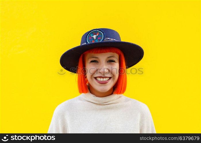 Attractive girl with a hat over a yellow wall