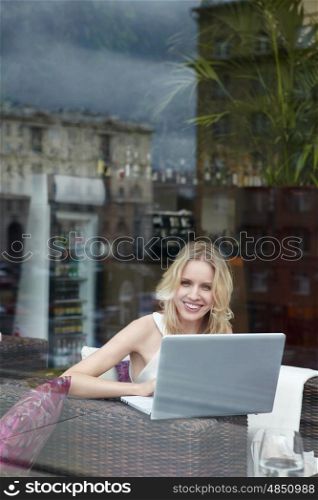 Attractive girl with a laptop in a cafe