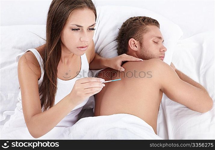 Attractive girl with a pregnancy test a man wakes up