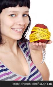 attractive girl with apple and tape measure in the hand a over white background