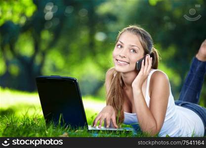 Attractive girl with laptop talking on the phone