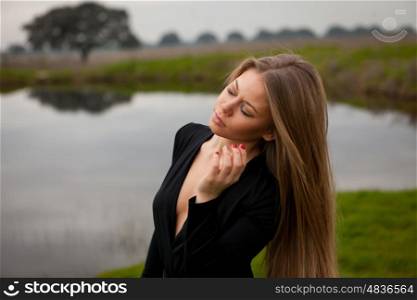 Attractive girl with long hair and sexy black shirt in the field