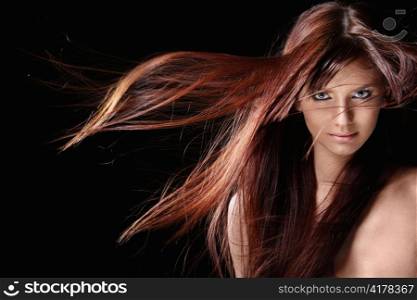 Attractive girl with red hair on a black background