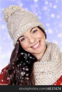 Attractive girl with with wool hat and scarf isolated on blue backgraund with snow