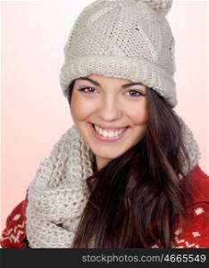 Attractive girl with with wool hat and scarf isolated on orange background
