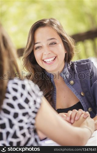 Attractive Girlfriends Laughing Sitting Outdoors.