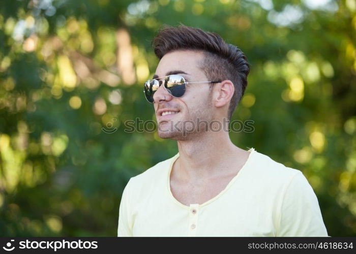 Attractive guy in the park with sunglasses and yellow t-shirt