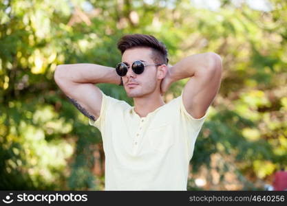 Attractive guy in the park with sunglasses and yellow t-shirt