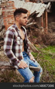 Attractive guy showing his strong chest and abs with the plaid shirt open