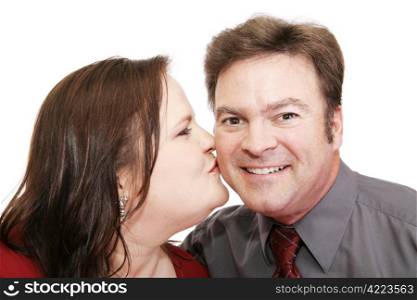 Attractive guy surprised by a kiss from his pretty girlfriend. White background. Perfect for Valentines Day.
