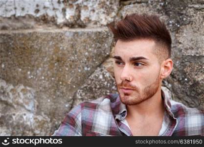 Attractive guy with beard and a old wall of background
