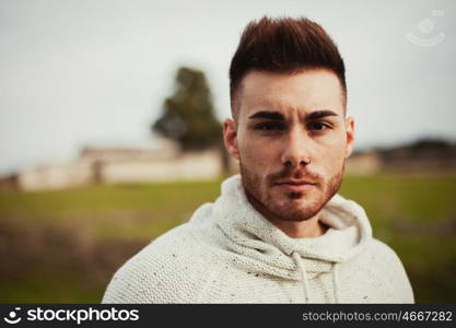 Attractive guy with beard in a green meadow