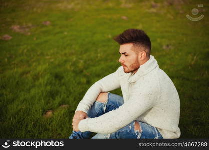 Attractive guy with beard in a green meadow