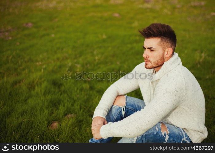 Attractive guy with beard in a green meadow