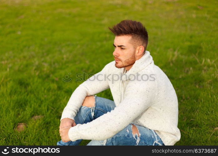 Attractive guy with beard in a green meadow