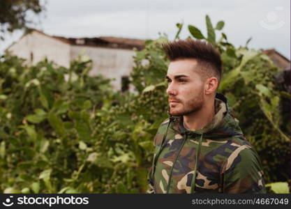 Attractive guy with military jacket and plants background