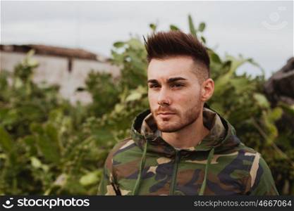 Attractive guy with military jacket and plants background