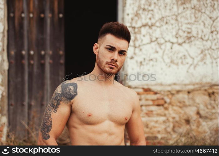 Attractive guy with the torso discovered showing his muscles