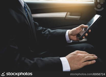 Attractive handsome young businessman using mobile smart phone in car.. Attractive handsome young businessman using mobile smart phone i