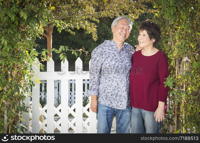 Attractive Happy Chinese Couple Enjoying Their House Outside.