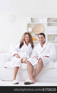 Attractive happy couple in robes at home