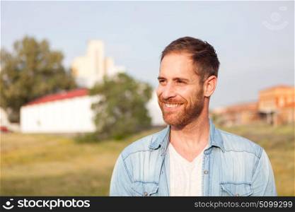 Attractive happy guy with a town of background