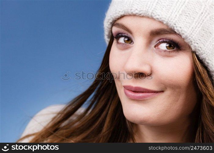 Attractive happy smiling woman long hair girl in winter wool cap studio shot on blue.. woman wearing winter wool cap portrait