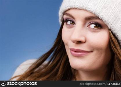 Attractive happy smiling woman long hair girl in winter wool cap studio shot on blue.. woman wearing winter wool cap portrait