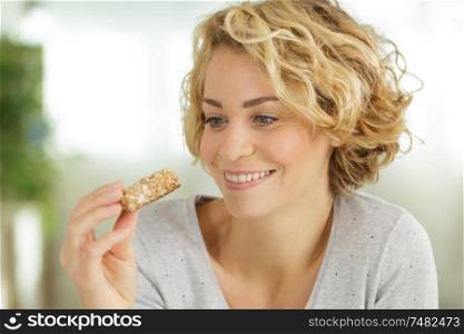 attractive lady holding a cereal bar