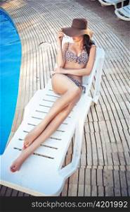 Attractive lady relaxing on swimming pool