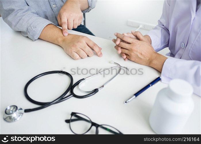 attractive Male doctor Examining discussing reports with Massage patient suffering from back pain in clinic